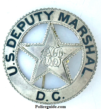 U. S. Deputy Marshal D. C. (District of Columbia, Washington D.C.) with the initials J. B. P. monogramed in the center.  This sterling silver badge was worn by J. B. Peyton and his name is inscribed on the back.