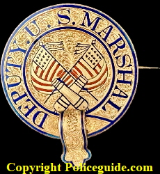 Post Civil War jeweler made Deputy U. S. Marshal badge made in the classic “police belt” design.  14k gold layered over a sterling silver base.  Red and blue hard fired enamel highlight the crossed U.S. flags and the crossed cannons.  