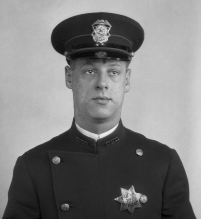 Officer J. W. Slagle wearing badge No. 102.  Badge is sterling and dated 10-14-19.
