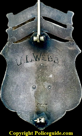    Seattle Police Detective Lieutenant No. 10 with 14k gold numbers in a blue enamel inside a 14k gold star, presented to V. L. Webb,  made of sterling silver with hard fired black enameled lettering.